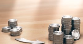 Two Piles of coins symbols on a wooden table and an arrow pointing the larger one. Financial profits concept. 3d illustration.
